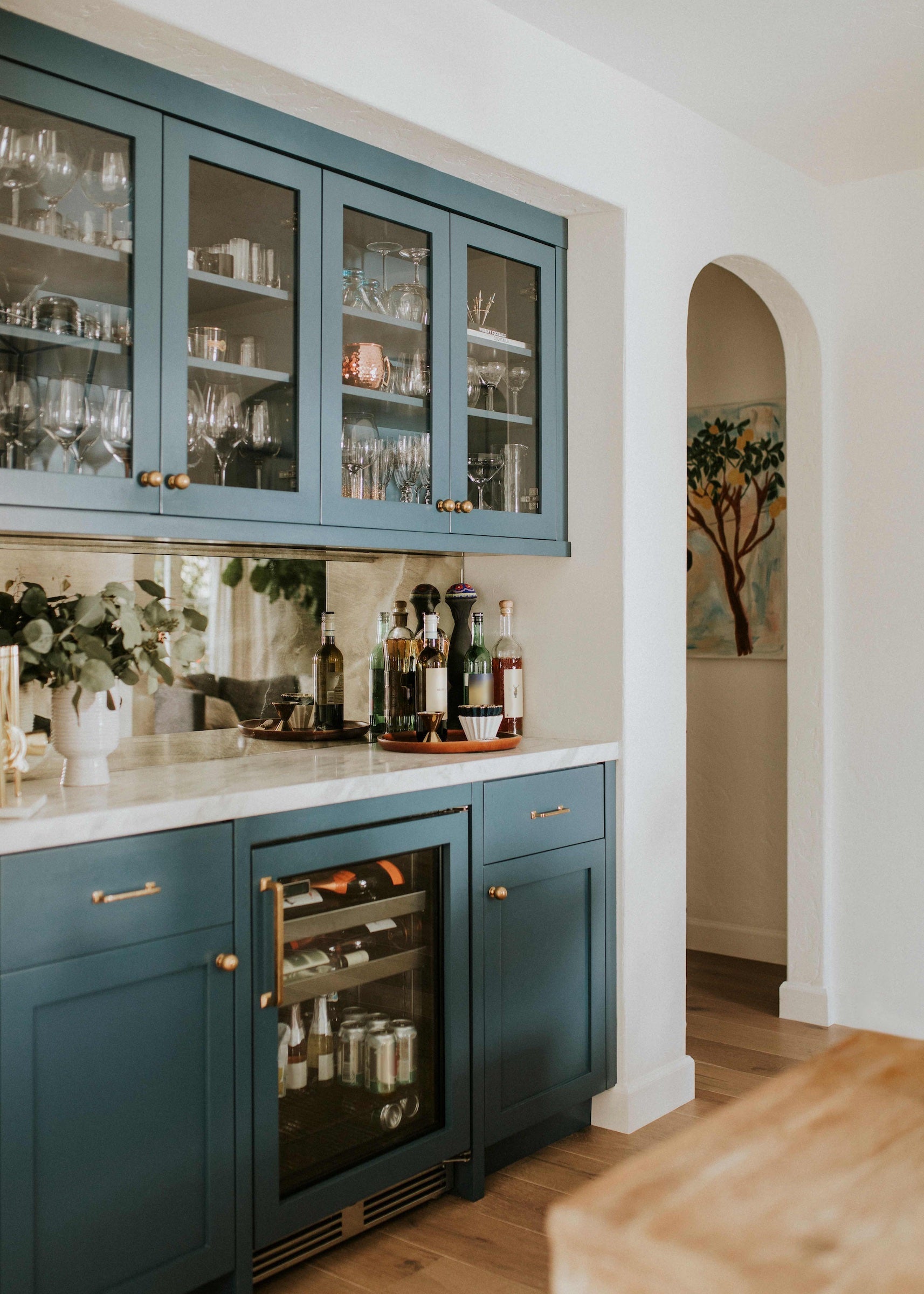 Custom wet bar with blue painted maple cabinetry and marble countertop by Reviving Dawn